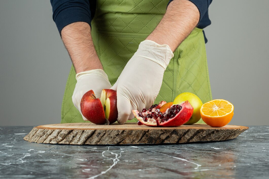 male-hand-gloves-cutting-red-apple-marble-table_2831-7965